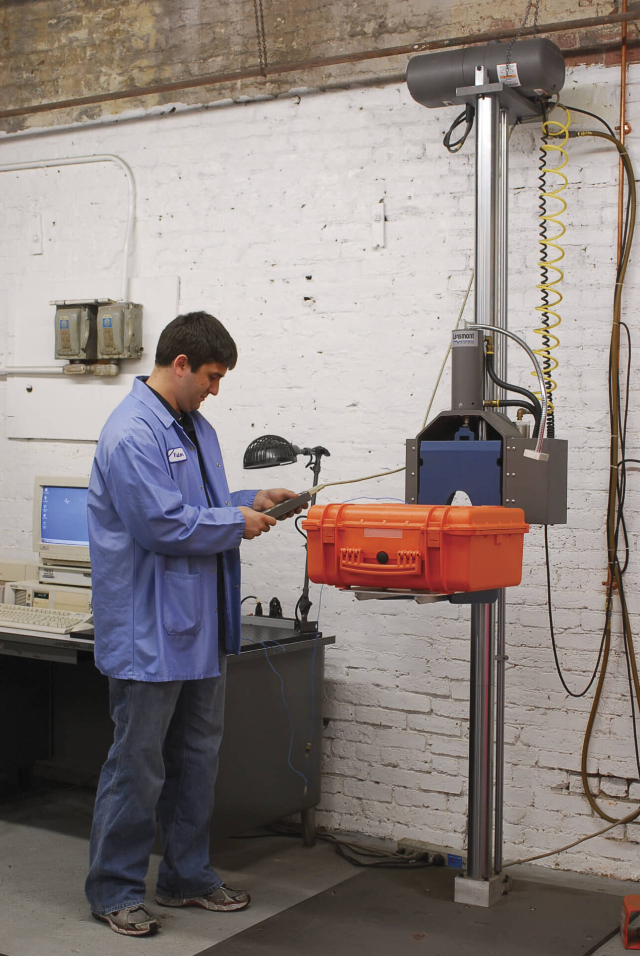 A man in blue lab coat working on an orange basket.