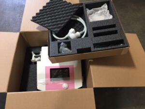 A box with some headphones and a pink camera