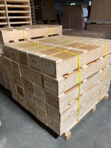 A large stack of wooden crates in a warehouse.