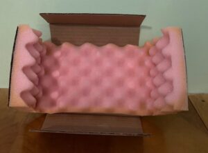 A cardboard box with pink foam on it.