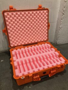 A large orange case with pink foam on top.